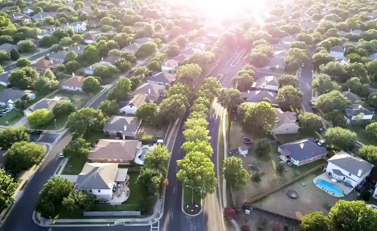 Aerial view at sunrise over a leafy residential neighbourhood